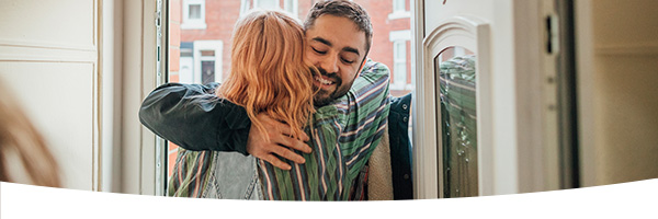 Meisje en jongen omhelzen in deuropening Meisje en jongen omhelzen in deuropening