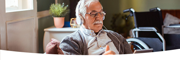 Senior man met koptelefoon op