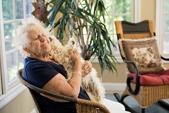 Oudere vrouw knuffelt hondje